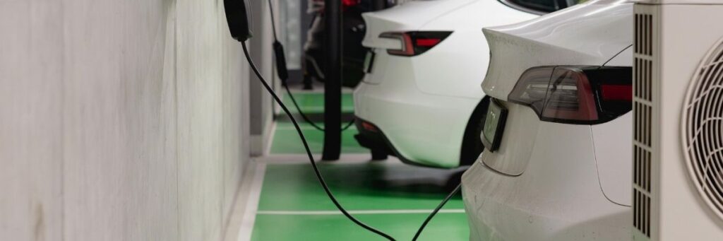 Laadplein bij bedrijfspand met zakelijke laadpaal, batterijopslag en zonnepanelen – slimme oplossing voor netkosten in 2025